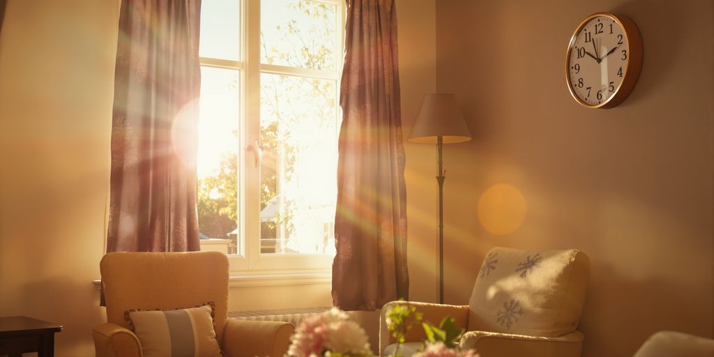 Cozy room with golden hour sunlight and a clock.
